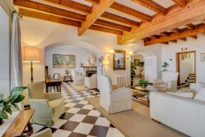 a living room with white furniture and a checkered floor at Hotel Sis Pins in Port de Pollensa