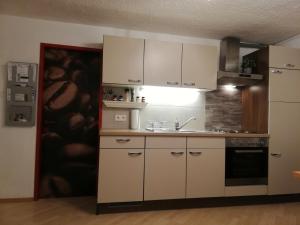eine Küche mit weißen Schränken und einer Spüle in der Unterkunft Studio in Tulfes