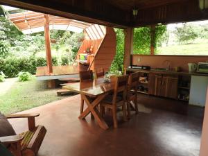 een keuken en eetkamer met een tafel en stoelen bij Mei Tai Cacao Lodge in Bijagua