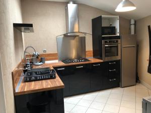 y cocina con fogones y nevera. en Spacieux appartement 2/6 pers 110m² proche CNPE, en Lagnieu