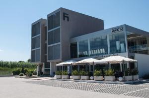 a large building with umbrellas in front of it at Hotel I Crespi in Grosseto
