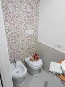 a bathroom with a white toilet and a sink at Affitta Camere da Nonna Maria in Lesina