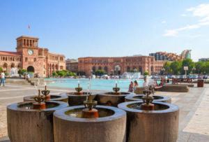 a fountain in front of a building with a clock tower at Luxury Apartment with jacuzzi on Republic Square in Yerevan