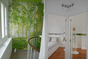 ein Schlafzimmer mit einem Wandbild von Bäumen in der Unterkunft VILLA CAMILLE - Proche Paris & Disneyland in Lagny