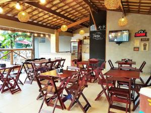 a restaurant with wooden tables and chairs in a room at Hotel Pousada do Sol in Aracaju