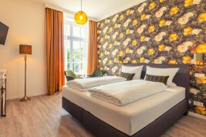 2 camas en un dormitorio con una pared floral en Rochter Landhotel en Zeltingen-Rachtig