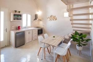 eine Küche mit einem Holztisch und weißen Stühlen in der Unterkunft Bonita Vista in Vóthon