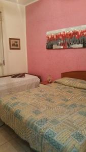 2 letti in una camera con pareti rosa di Appartamento Gallipoli a Gallipoli