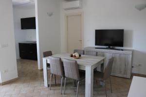 - une salle à manger avec une table, des chaises et une télévision dans l'établissement Atmosphera Casarano, à Casarano