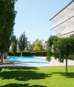 a swimming pool in front of a building at Apartamentos Sunway Atlanta in Sitges