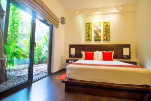 a bedroom with a large bed with red pillows at Villa Escondite - The Hotel in Sri Jayewardenepura Kotte