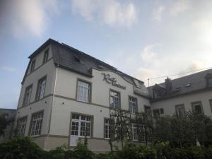 a white building with a sign on the side of it at Rochter Landhotel in Zeltingen-Rachtig