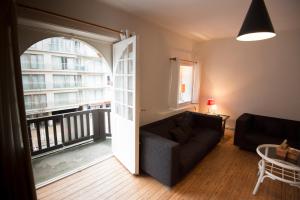 a living room with a couch and a balcony at Clos Normand in Nieuwpoort