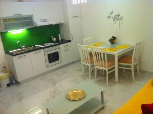 uma cozinha com uma mesa e uma cozinha com uma parede verde em Apartment Dea em Split