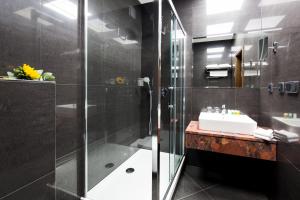 a bathroom with a glass shower and a sink at Hotel Selsky Dvur - Bohemian Village Courtyard in Prague