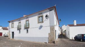 a white building with a light on the side of it at Lavradores Boutique Guesthouse in Évora