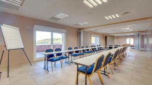 a classroom with tables and chairs and a whiteboard at Vacancéole – Le Domaine de Camiole in Callian