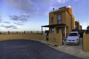 a white car parked in front of a house at Villadunas - with luxury hot tub in Corralejo