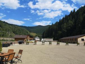 um parque de estacionamento com cadeiras e mesas e uma montanha em D' Magic em Broşteni