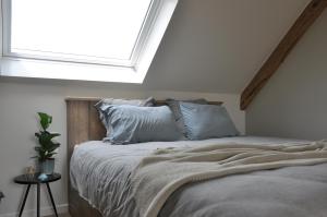 Schlafzimmer mit einem Bett und einem großen Fenster in der Unterkunft Bed en Bezem in Laarne
