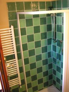 y baño con ducha de azulejos verdes y azules. en Borghetto Di San Filippo, en Barberino di Val d'Elsa
