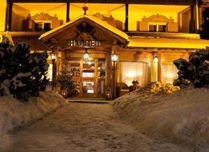 un hotel en la nieve por la noche en Villa Martha Vintage Hotel-B&B, en Santa Cristina Valgardena