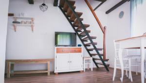 sala de estar con escalera y TV en NATURALINA HOLIDAY HOUSE, en Tribussa Superiore