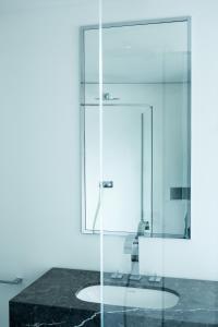 La salle de bains est pourvue d'une douche en verre et d'un lavabo. dans l'établissement The Fourth - Tafelrond, à Louvain