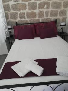 a bed with two pillows and a towel on it at Zanicovo beach apartment in Komiža