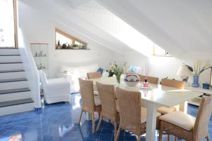 a dining room with a white table and chairs at La Soffitta Sul Mare in Vietri sul Mare