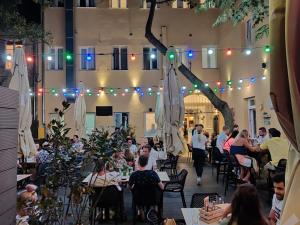 un grupo de personas sentadas en mesas en un edificio en Downtown Boutique Hostel, en Zadar