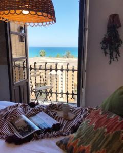 Apartamentos Boutique Villavieja في أليكانتي: غرفة بسرير مع اطلالة على الشاطئ
