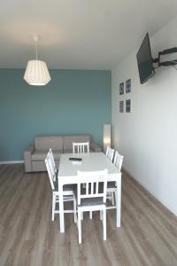 Un comedor con una mesa y sillas blancas. en Holiday House, en Chioggia