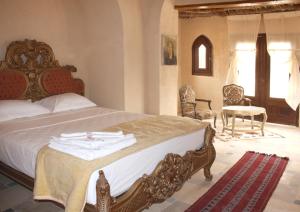 a bedroom with a bed with towels on it at Shanda Lodge Desert Resort in Al Qaşr