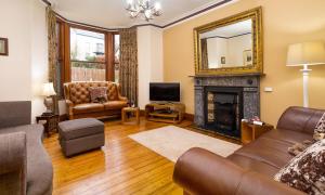 a living room with a couch and a fireplace at Highfield House in Ambleside