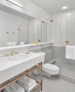 a bathroom with a sink and a toilet and a mirror at 21c Museum Hotel Chicago in Chicago