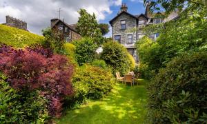 a garden with a table and chairs in front of a house at Highfield House in Ambleside