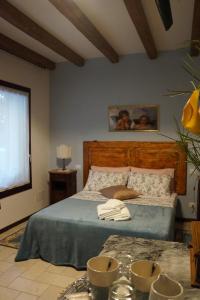 LA BRIGATA APARTMENTS Suite Room في كافالّينو تريبورتي: غرفة نوم بسرير وطاولة مع مناشف