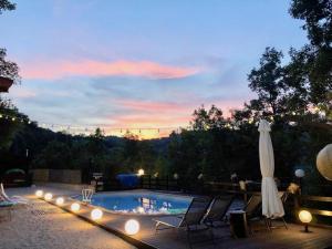 a pool with lights and chairs and a umbrella at Alloggio Rurale in Terni