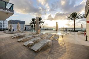 un grupo de tumbonas y sombrillas junto a una piscina en Monte Carlo by Miami Vacations, en Miami Beach