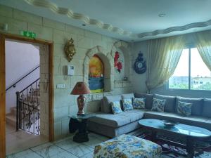 a living room with a couch and a table at La Colline de Chott Meriem appartements in Sousse