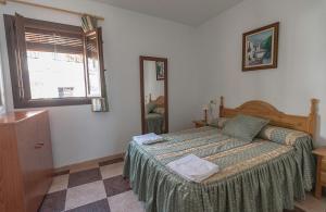 Schlafzimmer mit einem Bett und einem Fenster in der Unterkunft Apartamentos Rurales Las Chimeneas in Capileira