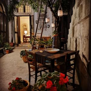 een houten tafel en stoelen in een kamer met potplanten bij Residenza Donnafugata B&B in Ragusa