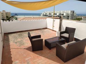 un patio avec des chaises et une table sur le toit dans l'établissement Relax and enjoy in brand new beach apartment I, à Los Llanos