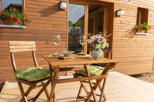 einen Holztisch mit 2 Stühlen und Weingläsern in der Unterkunft Fiechtehüsli (tiny house) in Huttwil