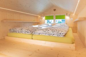 1 dormitorio con 1 cama en una habitación de madera en Fiechtehüsli (tiny house), en Huttwil