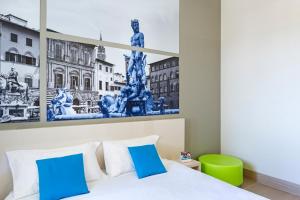 a bedroom with a painting on the wall at B&B Hotel Firenze Nuovo Palazzo Di Giustizia in Florence