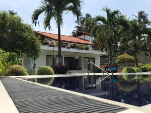 a house with a swimming pool in front of a house at Colibri Villa in Maggona West