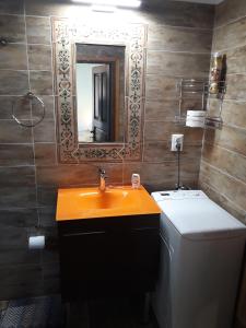 a bathroom with a sink and a toilet and a mirror at Eleni Country Cottage 2 in Feneos