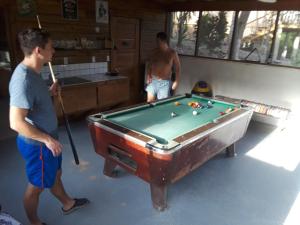 two men standing in a room with a pool table at Hidden Haven in Unitedville